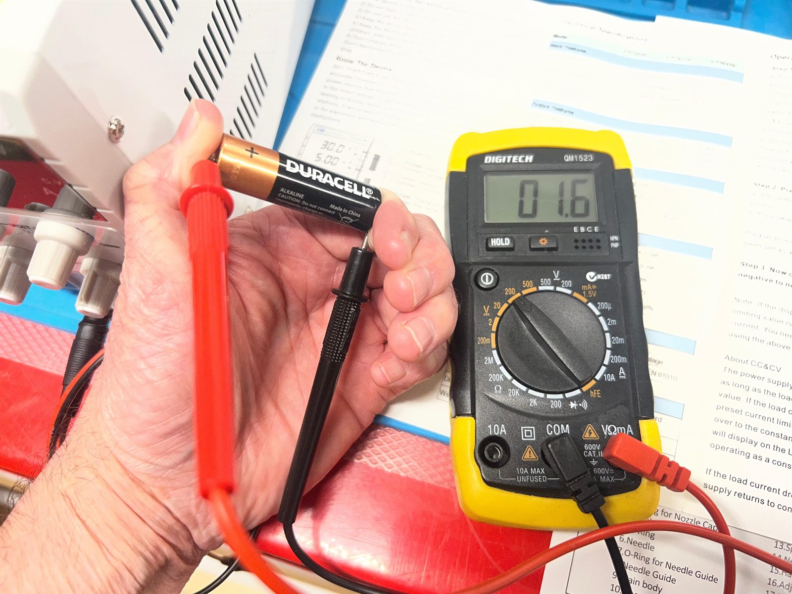 A Digitech QM1523 multimeter reading 1.6 volts from a fresh Duracell AA battery