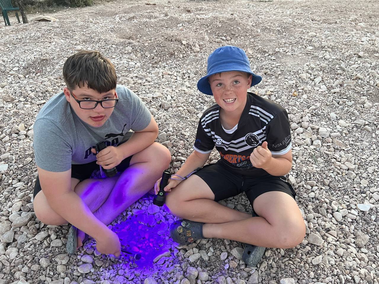 Two boys with their black lights on the mullock heaps