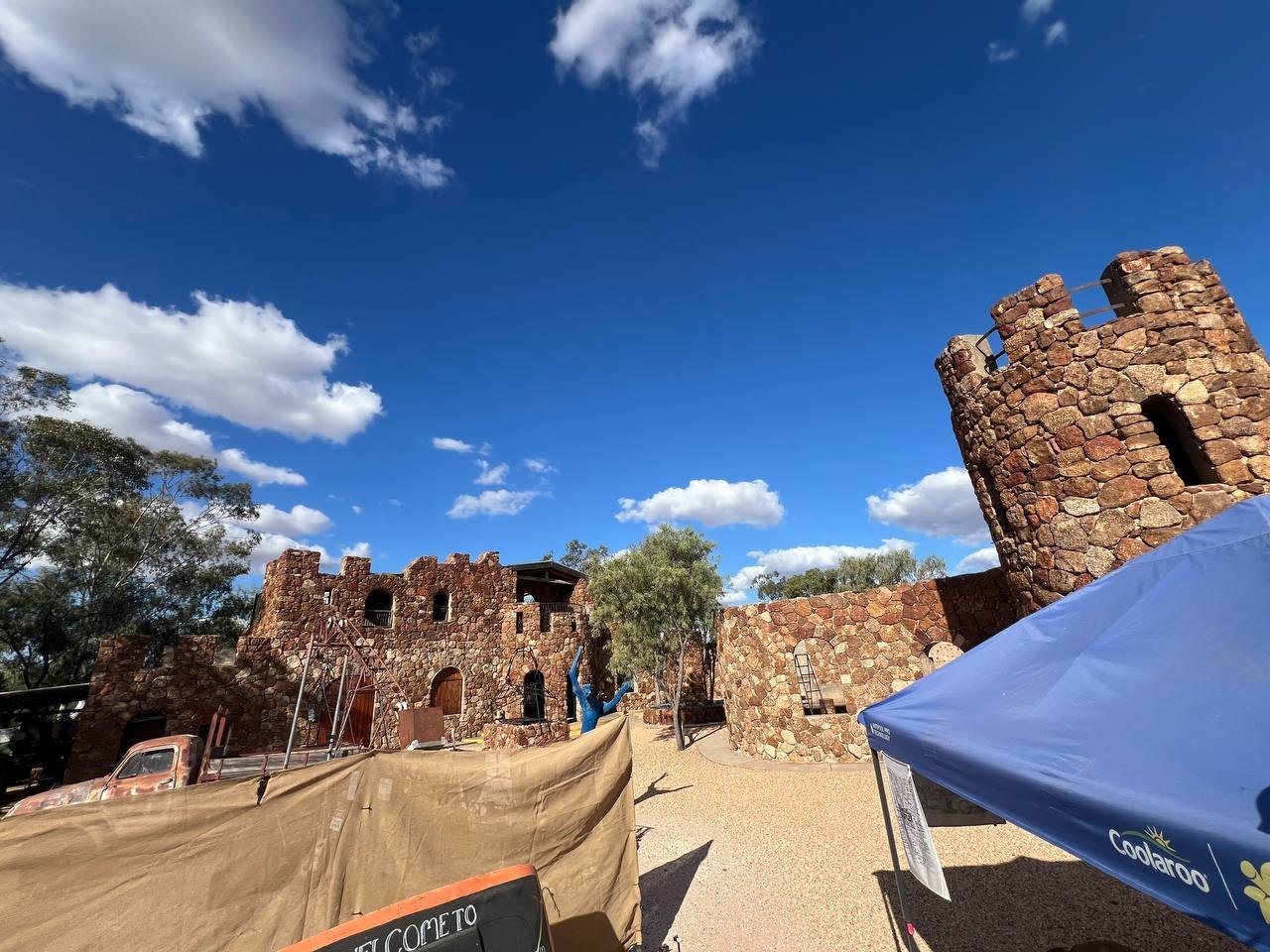 Amigo's Castle: reddish-brown stone walls and a tall crenellated tower against a blue sky